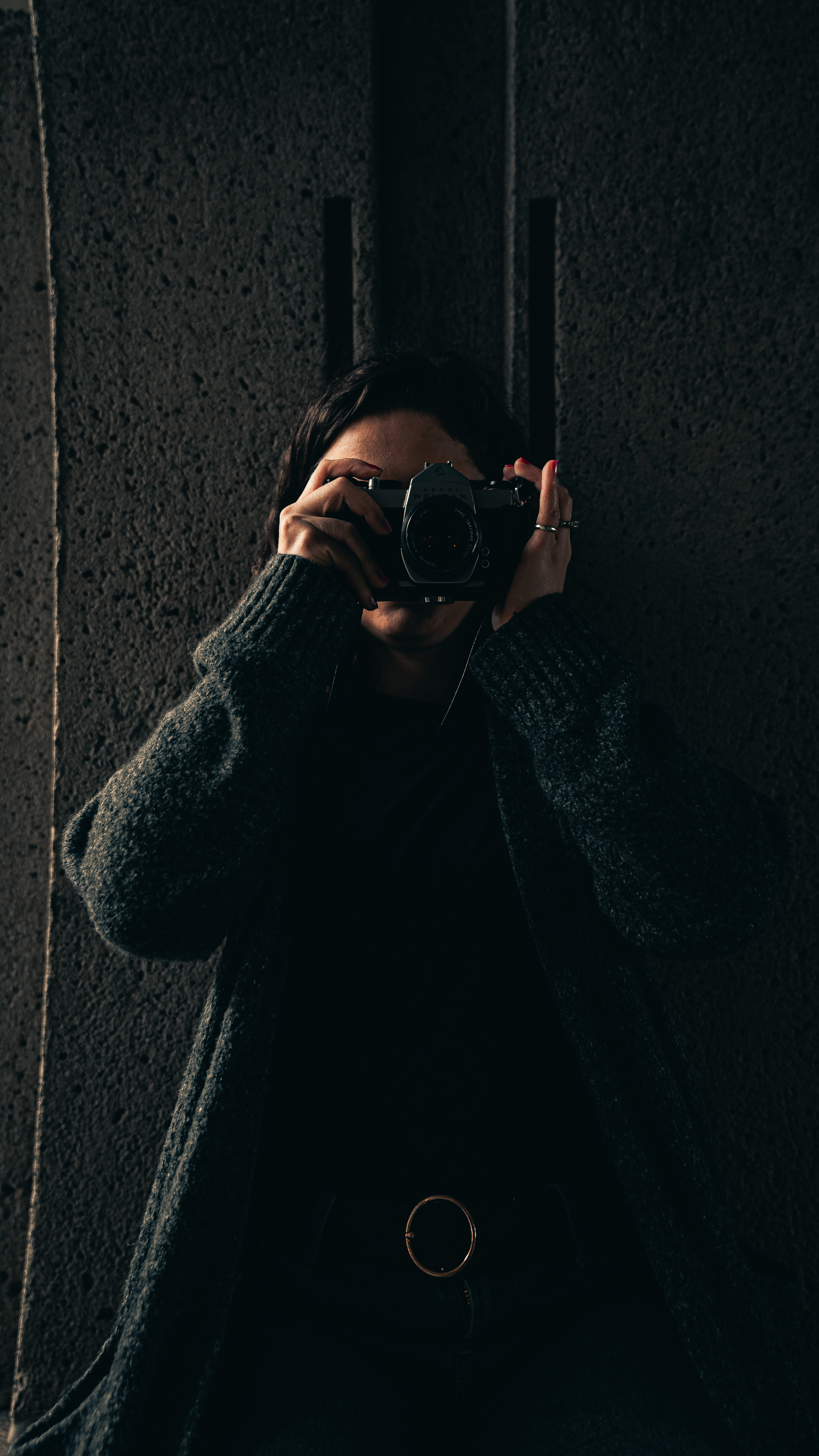 Moody self-portrait of photographer with camera in dramatic lighting