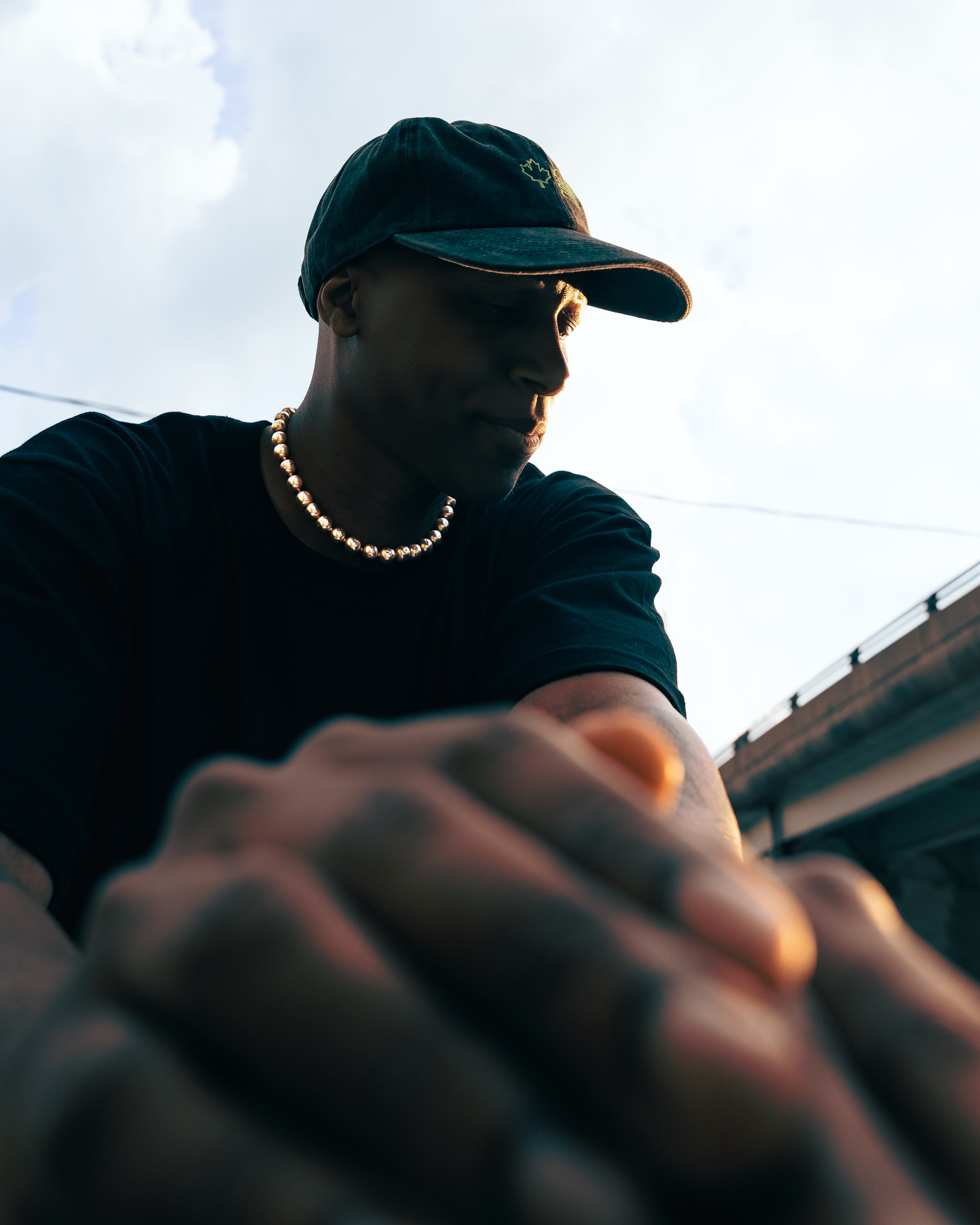 Street style portrait with green cap and gold chain at golden hour